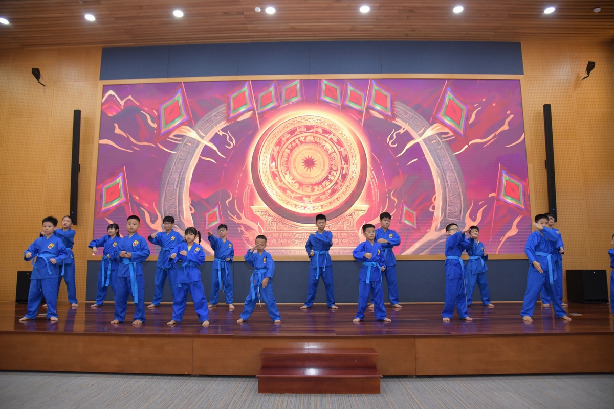 <p class="Normal"> Không khí chương trình chuyển sang mạnh mẽ với phần biểu diễn của lớp Võ Vovinam. Trong tiếng nhạc dồn dập, các võ sinh nhí thực hiện những kỹ thuật và bài quyền đã được học, thể hiện sự tập trung, dứt khoát và tinh thần kỷ luật. Phía sau mỗi thế võ là quá trình rèn thể lực, tập đi tập lại động tác và học cách làm chủ cơ thể. Với nhiều bạn nhỏ, đây cũng là lần đầu biểu diễn trước đông người. Màn trình diễn không chỉ giới thiệu kỹ năng tự vệ cơ bản mà còn cho thấy bản lĩnh và sự bền bỉ được bồi đắp qua từng buổi học.</p>