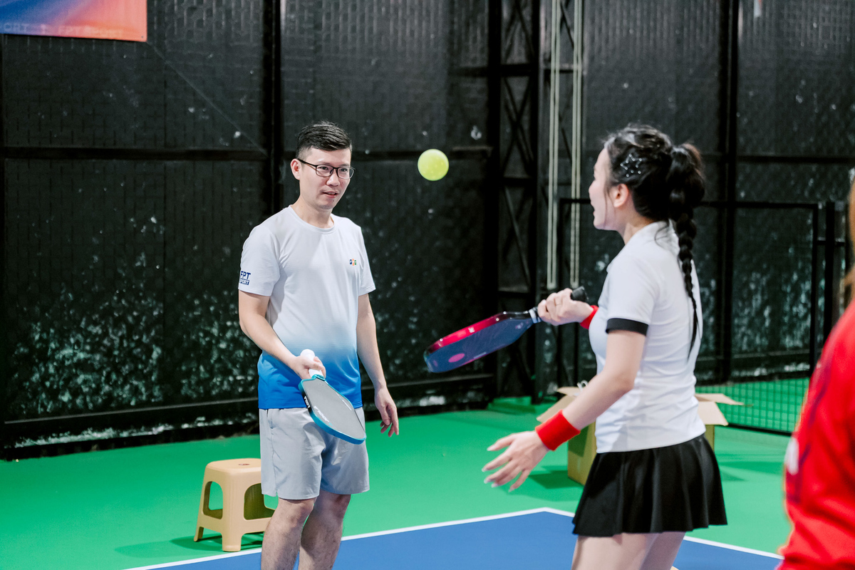 <p class="Normal" style="text-align:justify;"> Trong khi các trận đấu diễn ra liên tục, khu vực minigame cũng thu hút đông đảo VĐV và CĐV tranh thủ ghé qua thử sức. Người chơi có thể tham gia các thử thách như đánh bóng trúng túi quà, tâng bóng ziczac để mang về những phần thưởng thú vị. Không ít người hào hứng thử sức nhiều lần, vừa tìm kiếm niềm vui, vừa săn quà sau những giờ thi đấu căng thẳng.<br /> Chị Chu Thị Hằng, VĐV FPT HO “khoe” đã tham gia ba trò chơi và nhận được rất nhiều quà, vui vẻ nhận xét các minigame “rất hay, dễ chơi” và quà tặng thiết thực với người yêu pickleball.</p>